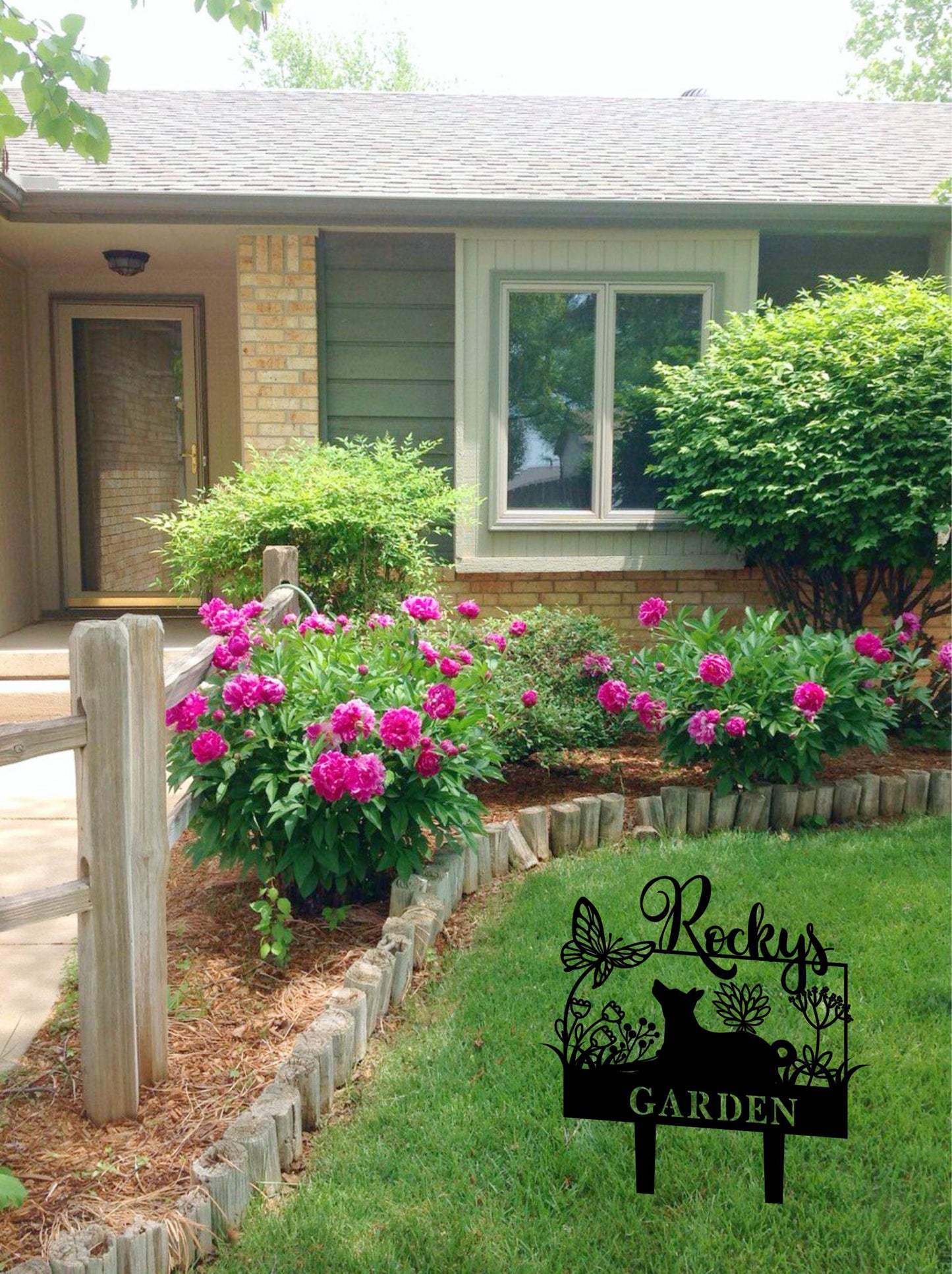 a garden with pink flowers in the front yard