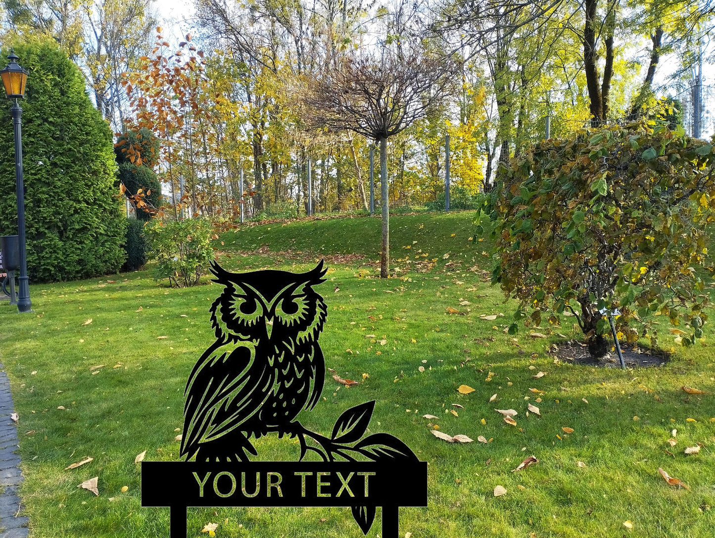an owl sitting on top of a sign in a park