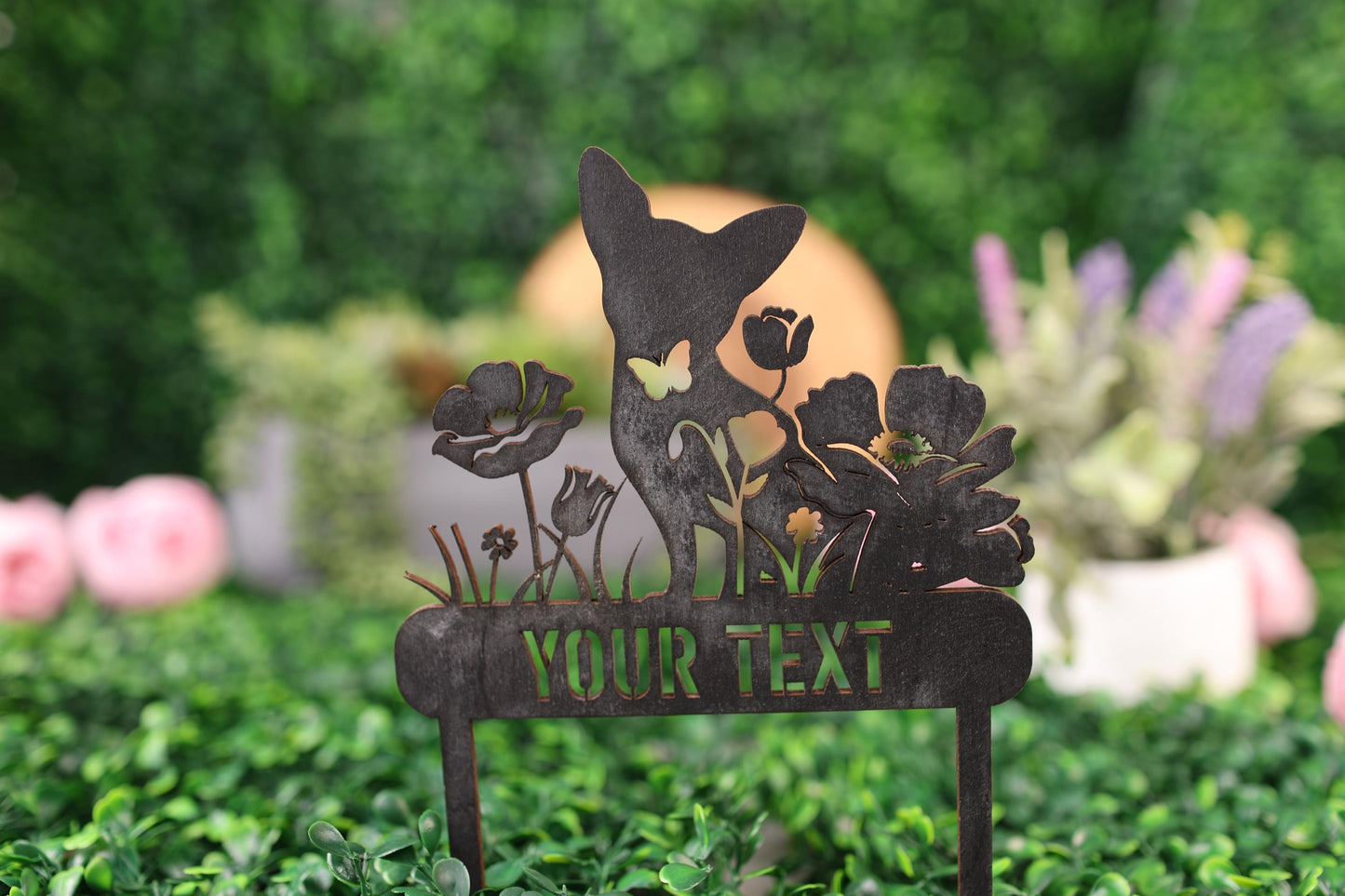 a metal sign with flowers on it in a field