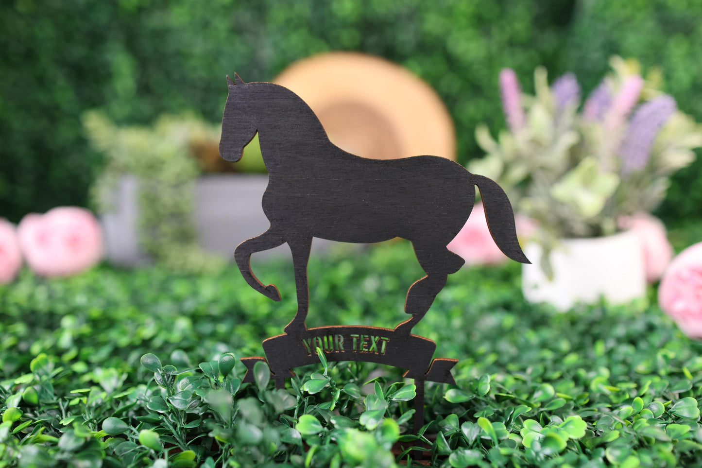 a wooden horse standing on top of a lush green field