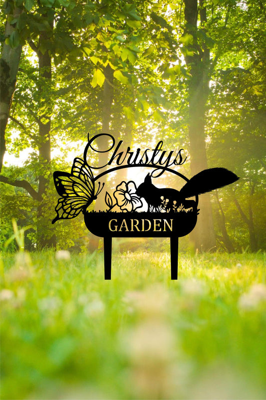 a garden sign sitting in the middle of a lush green field