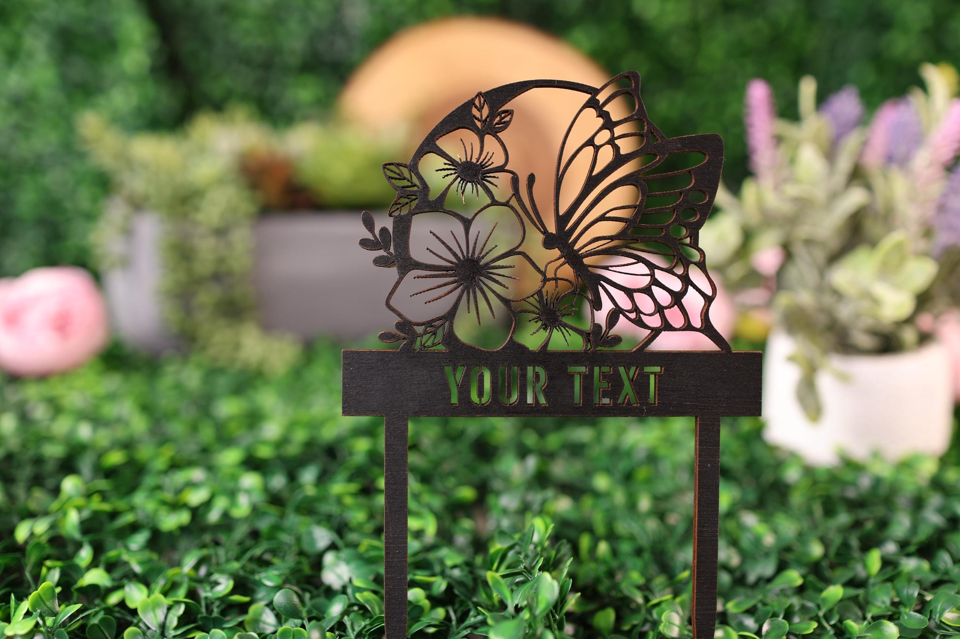 a metal sign with a butterfly and flowers on it