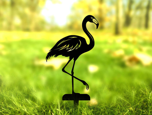 a silhouette of a flamingo standing in the grass