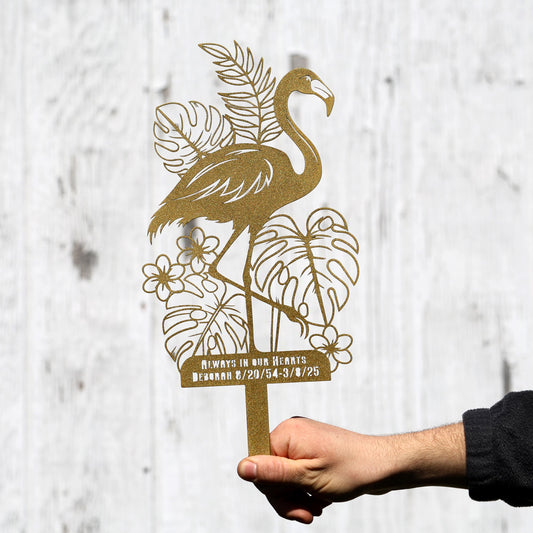 a person holding a metal sign with a flamingo on it