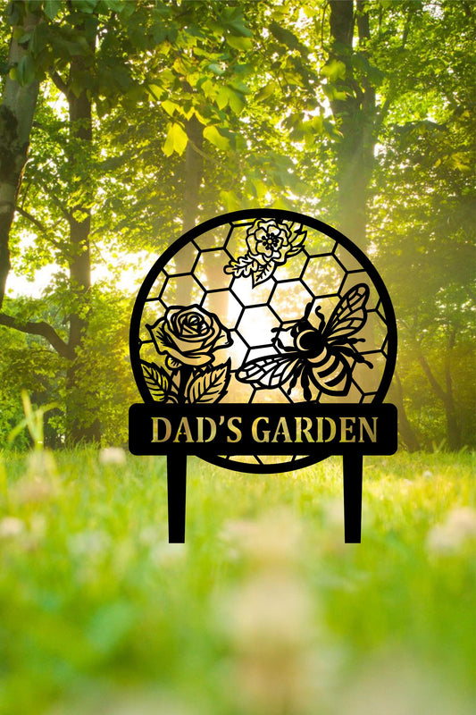 a garden sign sitting in the middle of a lush green field