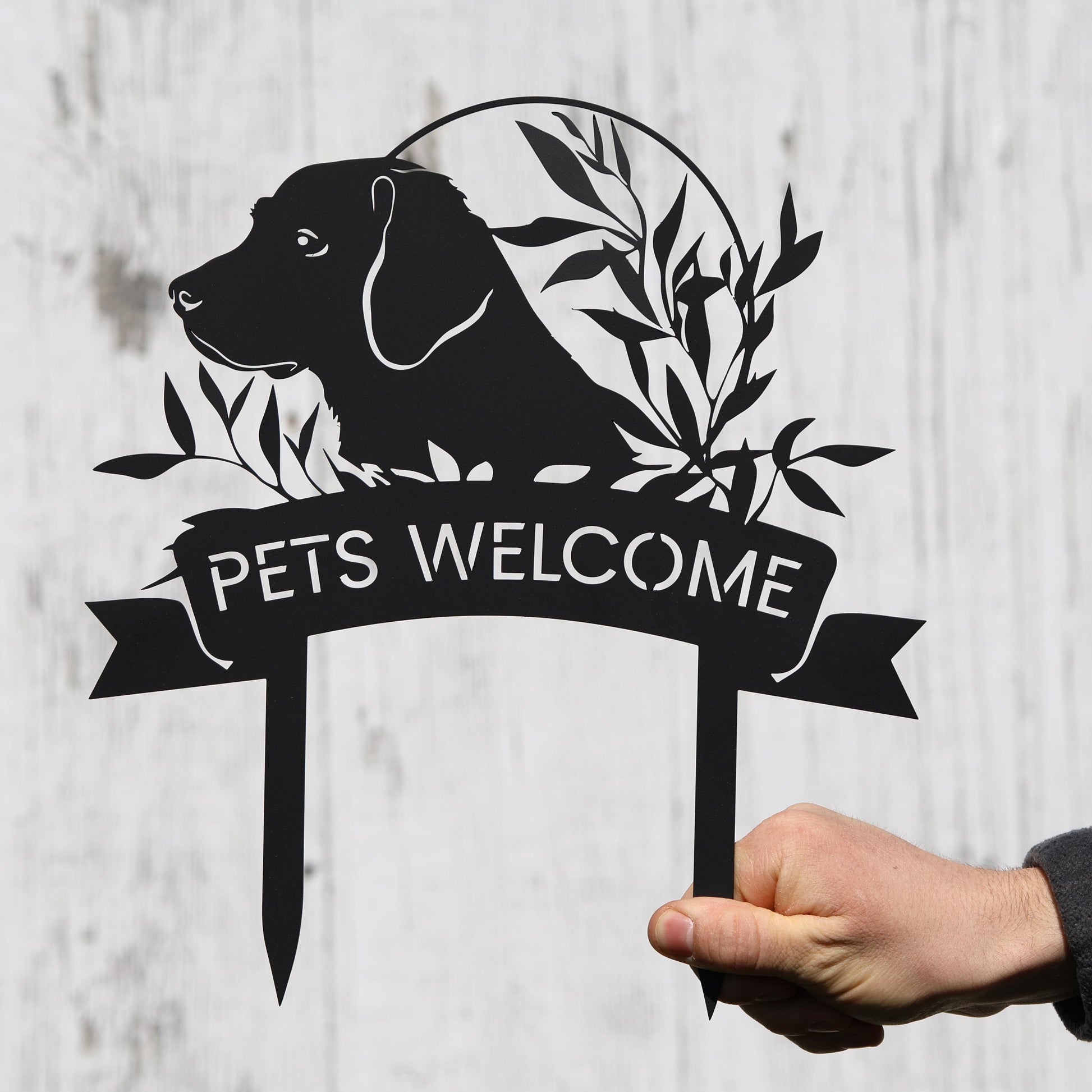 a hand holding a welcome sign with a dog on it