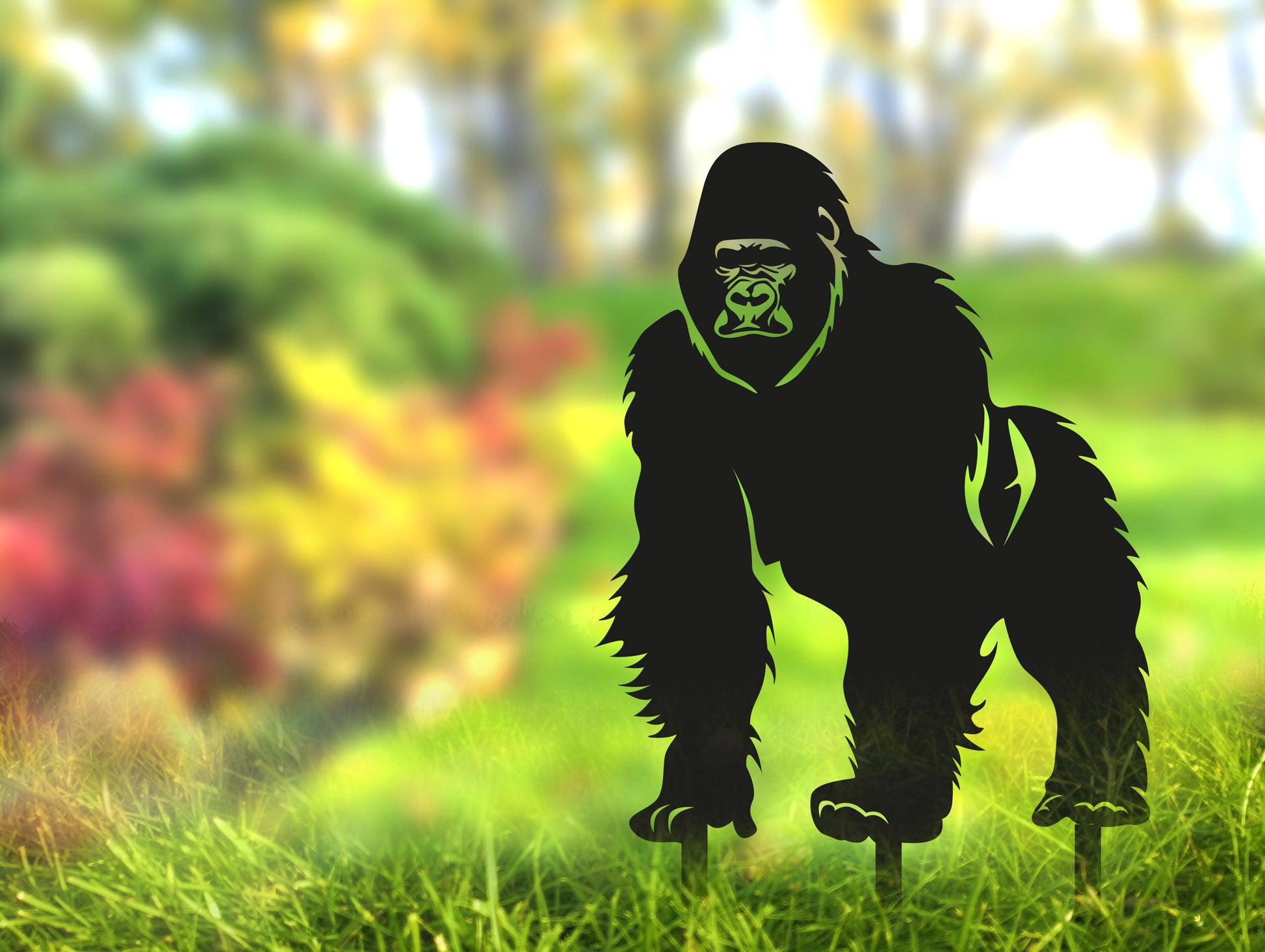 a silhouette of a gorilla standing in the grass
