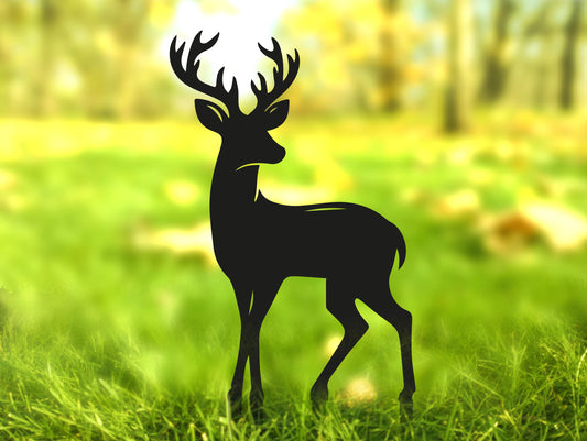 a silhouette of a deer standing in the grass