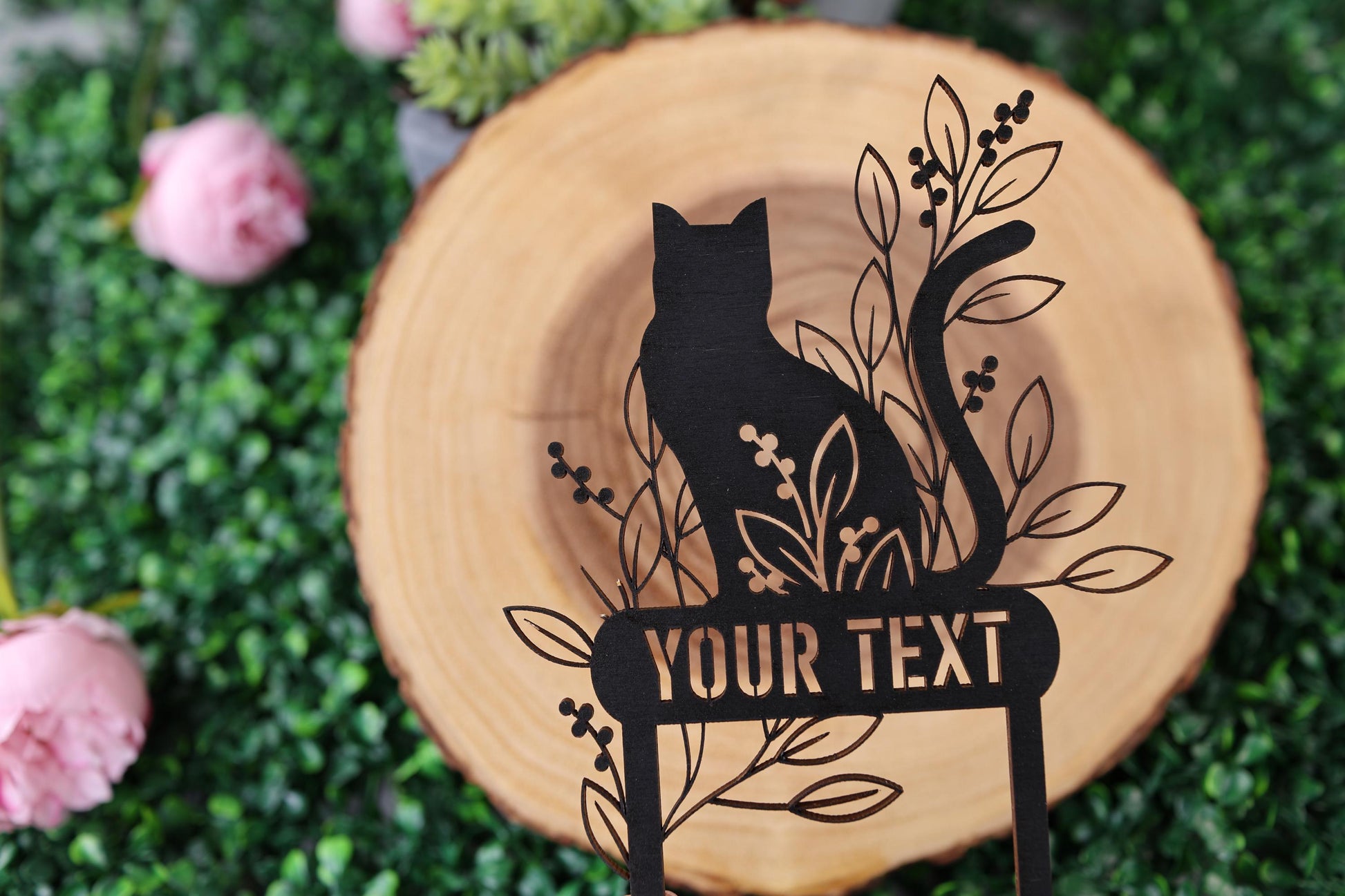 a black cat sitting on top of a wooden sign