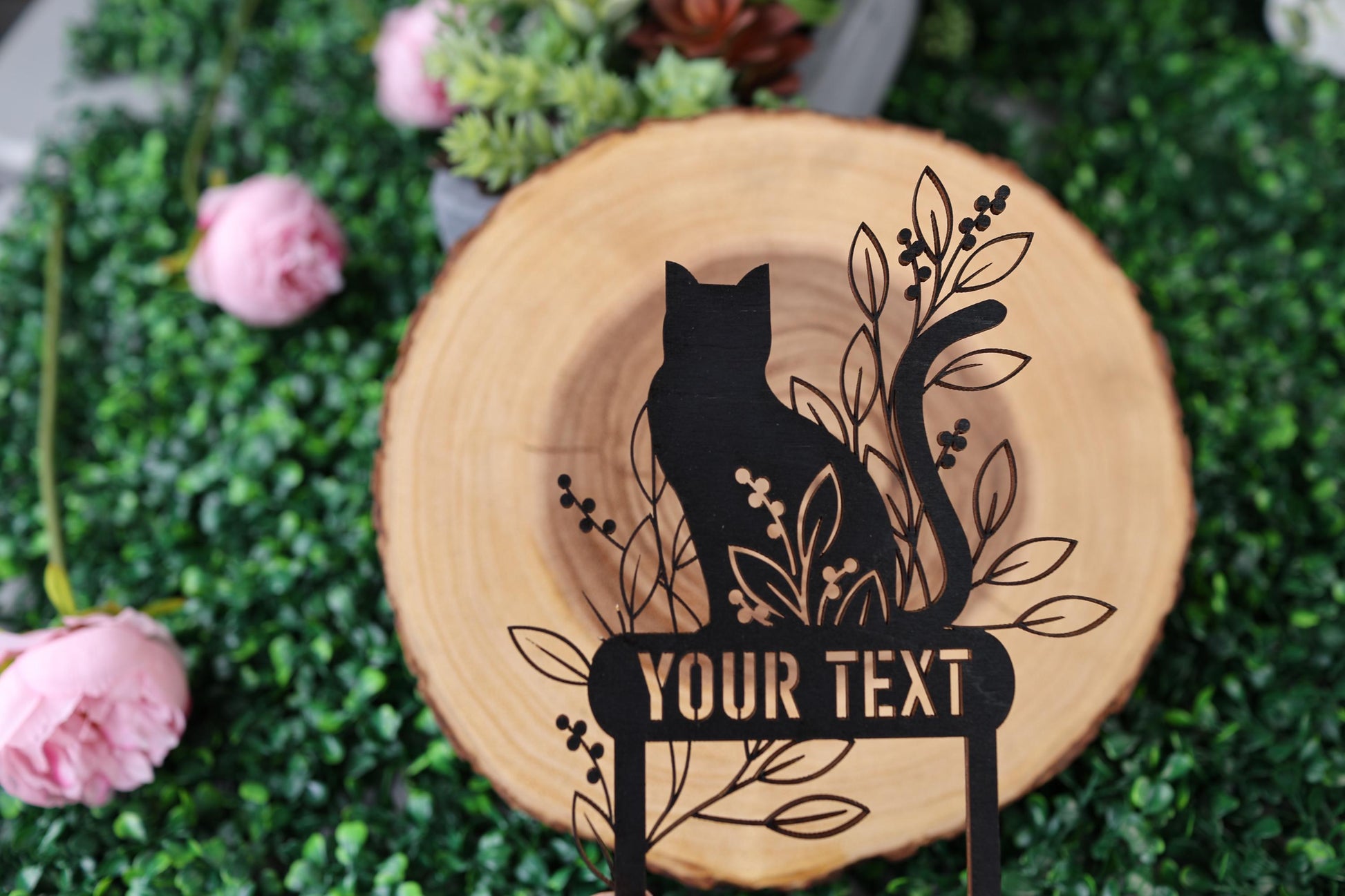 a black cat sitting on top of a wooden sign
